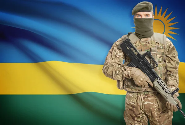 Soldier holding machine gun with flag on background series - Rwanda — стокове фото