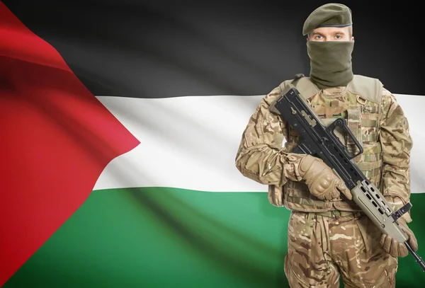 Soldier holding machine gun with flag on background series - Palestine — Zdjęcie stockowe