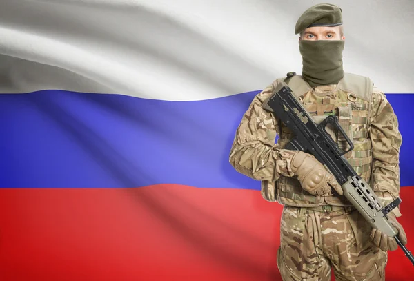 Soldier holding machine gun with flag on background series - Russia — Stock fotografie