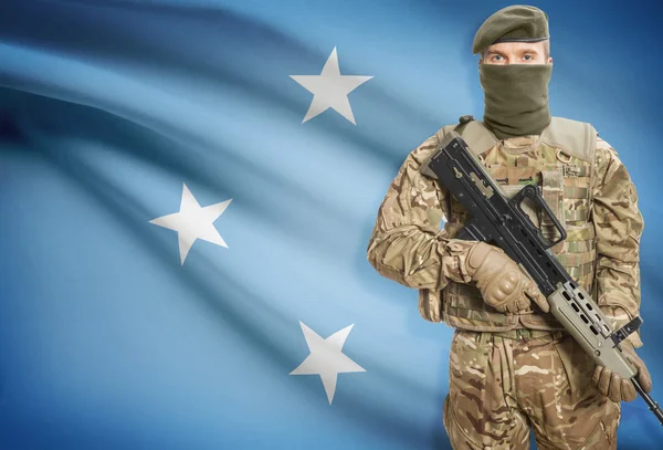 Soldier holding machine gun with flag on background series - Micronesia — Stok Foto