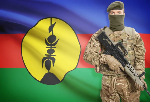 Soldier holding machine gun with flag on background series - New Caledonia — Zdjęcie stockowe