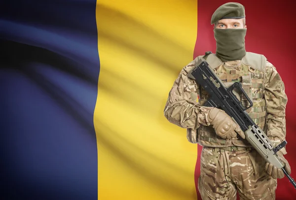 Soldier holding machine gun with flag on background series - Romania — Stockfoto