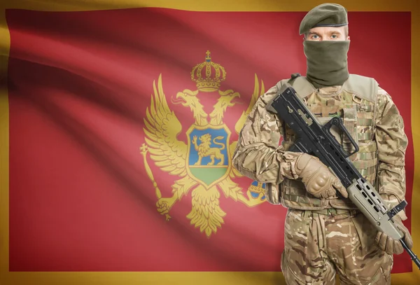 Soldier holding machine gun with flag on background series - Montenegro — Stok Foto