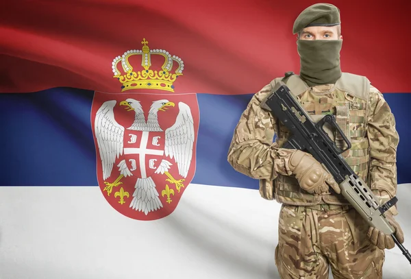 Soldier holding machine gun with flag on background series - Serbia — Fotografia de Stock