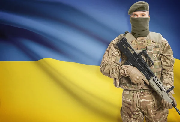 Soldier holding machine gun with flag on background series - Ukraine — Stock fotografie