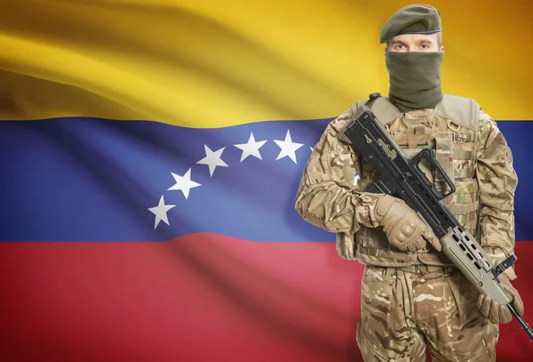 Soldier holding machine gun with flag on background series - Venezuela — Stock Photo, Image