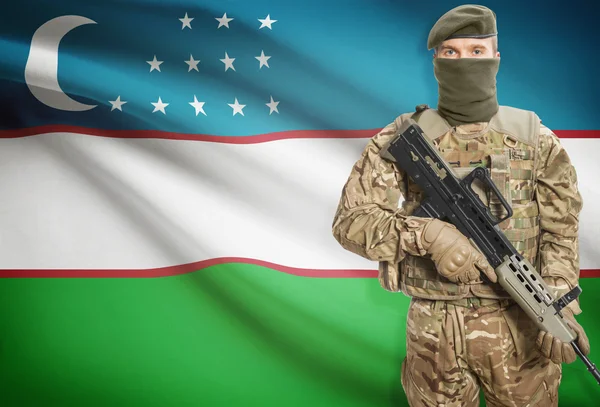 Soldier holding machine gun with flag on background series - Uzbekistan — Stok Foto