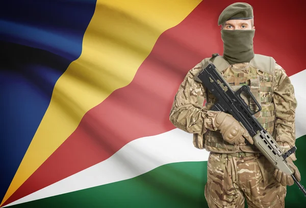 Soldier holding machine gun with flag on background series - Seychelles — Stockfoto