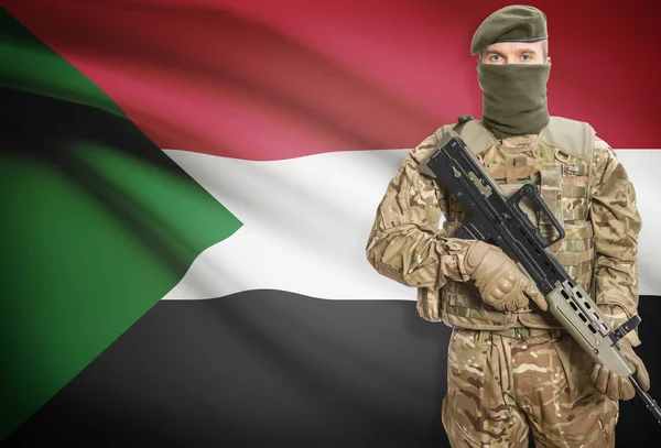 Soldier holding machine gun with flag on background series - Sudan — стокове фото
