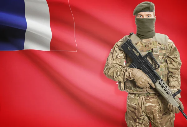 Soldier holding machine gun with flag on background series - Wallis and Futuna — kuvapankkivalokuva