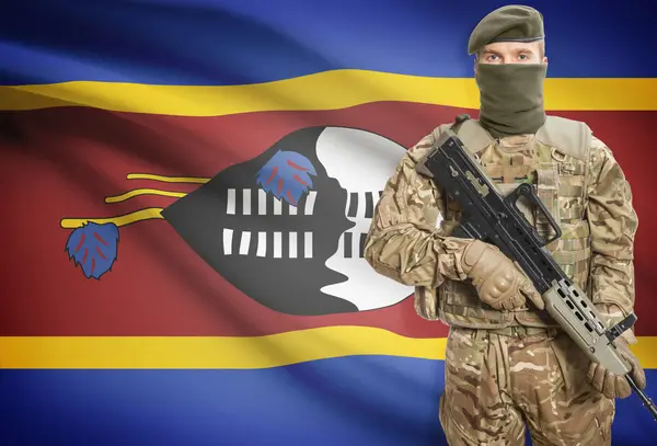 Soldier holding machine gun with flag on background series - Swaziland — Stok Foto