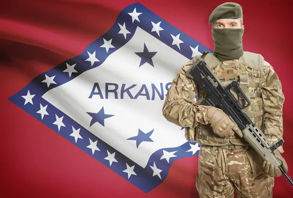 Soldier holding machine gun with USA state flag on background series - Arkansas — Stock Photo, Image