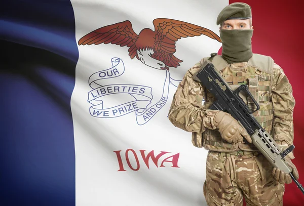 Soldier holding machine gun with USA state flag on background series - Iowa — Stok Foto