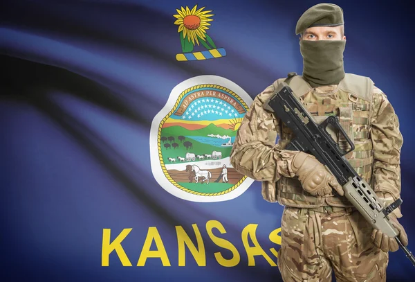 Soldier holding machine gun with USA state flag on background series - Kansas — Stok Foto