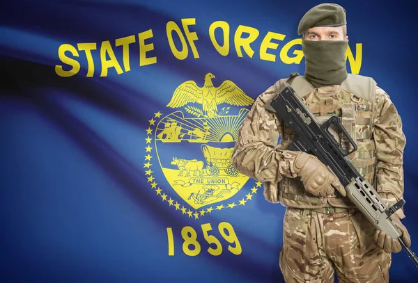 Soldier holding machine gun with USA state flag on background series - Oregon — Zdjęcie stockowe
