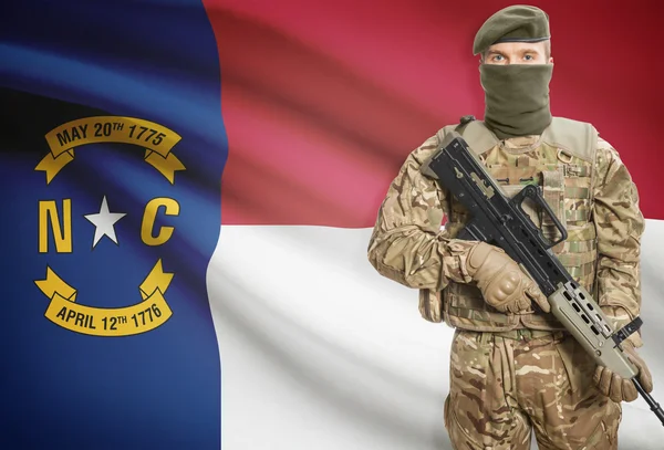 Soldier holding machine gun with USA state flag on background series - North Carolina — Stok fotoğraf