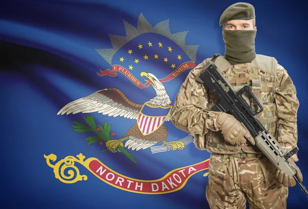 Soldier holding machine gun with USA state flag on background series - North Dakota — Stock Photo, Image