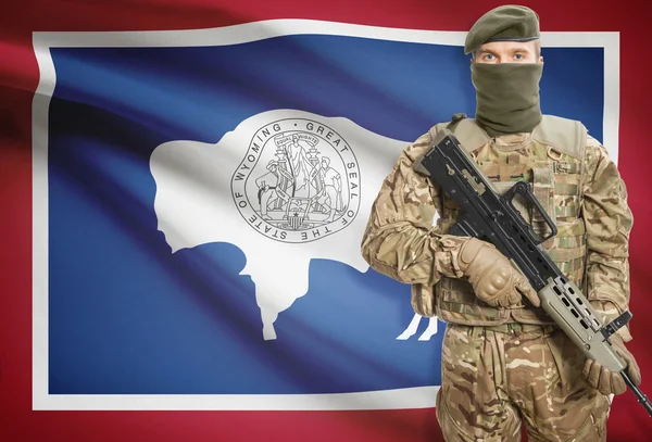 Soldier holding machine gun with USA state flag on background series - Wyoming — Stok Foto