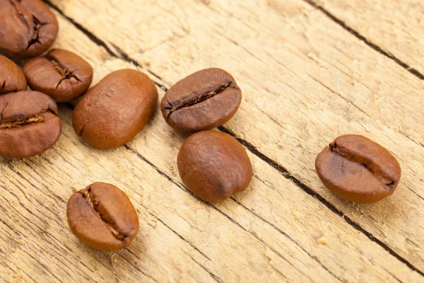 Well roasted coffee beans on old wooden table — Stock Photo, Image