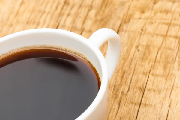 Close up shot of coffee cup on wooden table — Stock Photo, Image