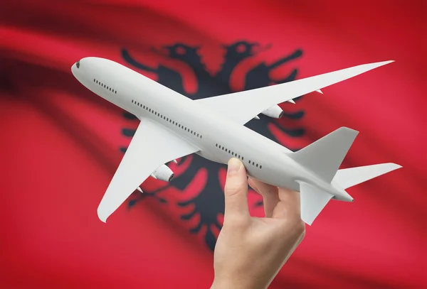 Airplane in hand with flag on background - Albania — Stock Photo, Image