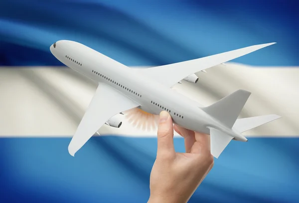 Airplane in hand with flag on background - Argentina — Stock Photo, Image