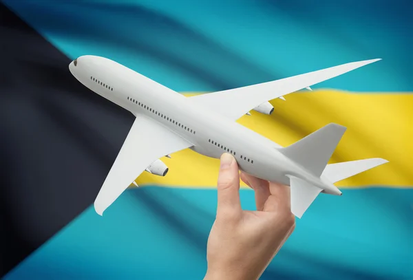 Avión en la mano con la bandera en el fondo - Bahamas —  Fotos de Stock