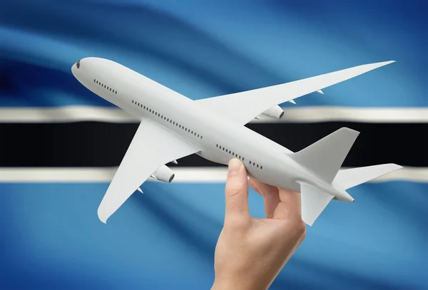 Airplane in hand with flag on background - Botswana — Stock Photo, Image