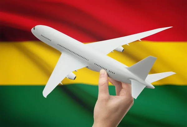 Airplane in hand with flag on background - Bolivia — Stock Photo, Image