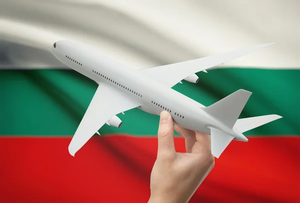 Flugzeug in der Hand mit Flagge auf Hintergrund - Bulgarien — Stockfoto
