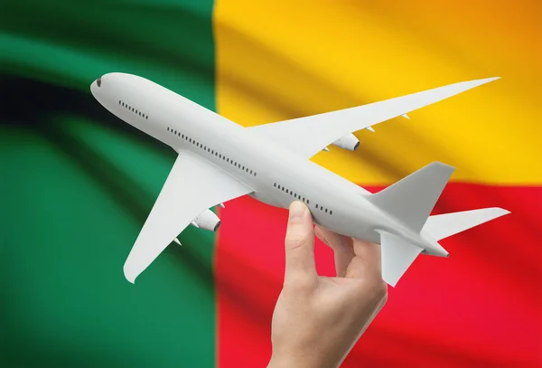 Airplane in hand with flag on background - Benin — Stock Photo, Image