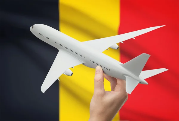 Airplane in hand with flag on background - Belgium — Stock Photo, Image