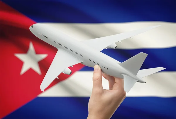 Avión en la mano con la bandera en el fondo - Cuba — Foto de Stock