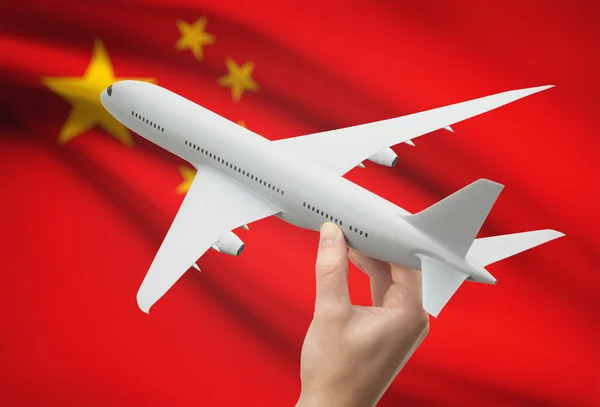 Airplane in hand with flag on background - China — Stock Photo, Image