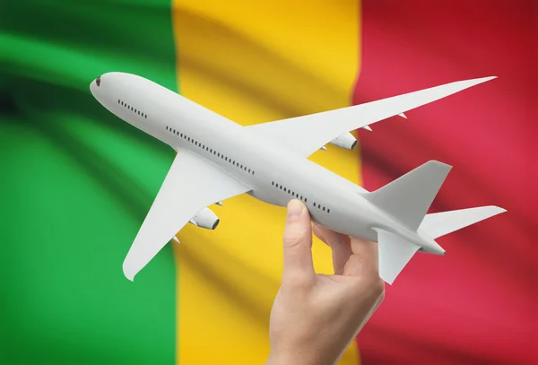 Airplane in hand with flag on background - Mali — Stock Photo, Image