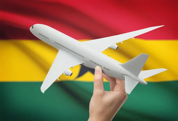 Avión en la mano con la bandera en el fondo - Ghana —  Fotos de Stock