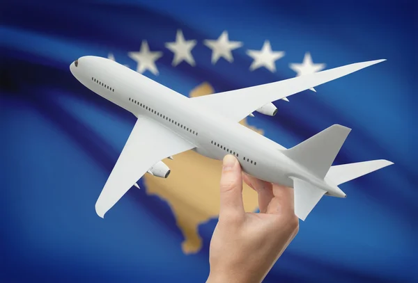 Airplane in hand with flag on background - Kosovo — Stock Photo, Image