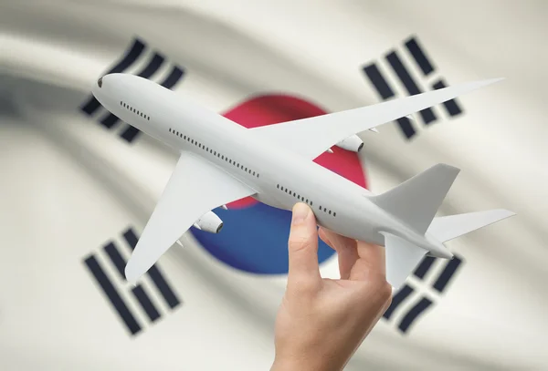 Avião na mão com a bandeira no fundo - Coreia do Sul — Fotografia de Stock