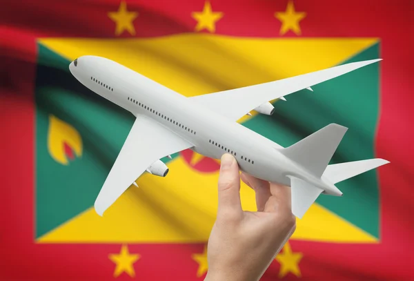 Airplane in hand with flag on background - Grenada — Stock Photo, Image