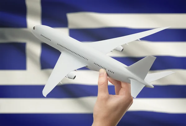 Avión en la mano con la bandera en el fondo - Grecia —  Fotos de Stock