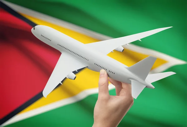 Airplane in hand with flag on background - Guyana — Stock Photo, Image