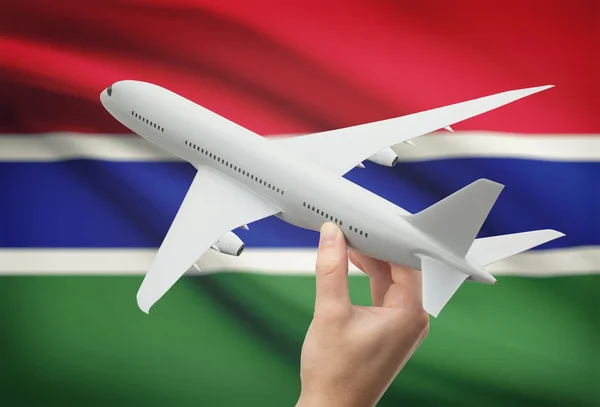 Самолет в руку с флагом на фоне - Гамбия — стоковое фото