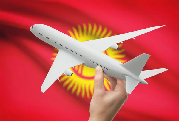 Airplane in hand with flag on background - Kyrgyzstan — Stock Photo, Image