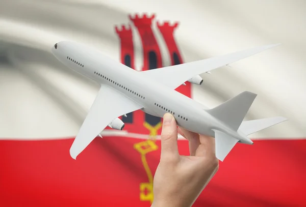 Airplane in hand with flag on background - Gibraltar — Stock Photo, Image