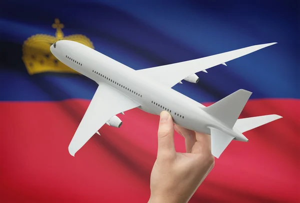 Flugzeug in der Hand mit Flagge auf Hintergrund - Liechtenstein — Stockfoto