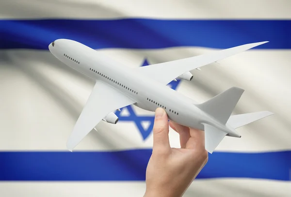 Flugzeug in der Hand mit Flagge auf Hintergrund - Israel — Stockfoto