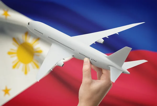 Samolot w rękę z flagą na tła – Filipiny — Zdjęcie stockowe
