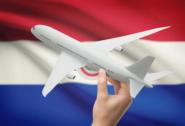 Flugzeug in der Hand mit Flagge auf Hintergrund - Paraguay — Stockfoto