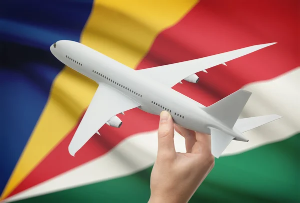 Airplane in hand with flag on background - Seychelles — Stock Photo, Image