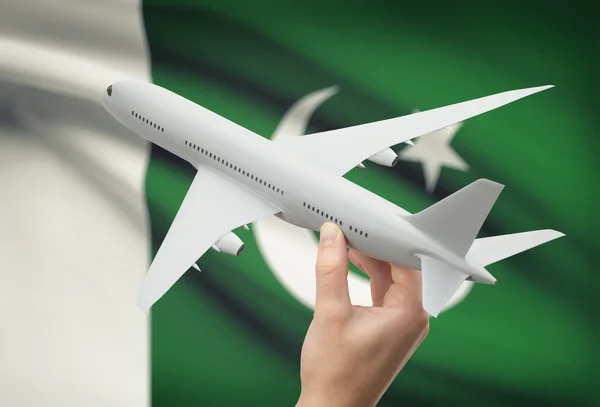Airplane in hand with flag on background - Pakistan — Stock Photo, Image